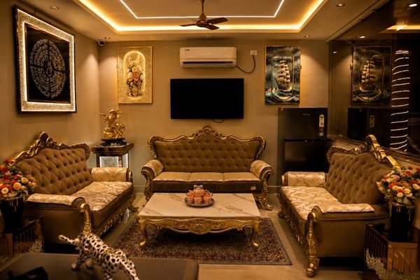 Executive VIP guest lounge with opulent sofa seating, modern entertainment, and artwork