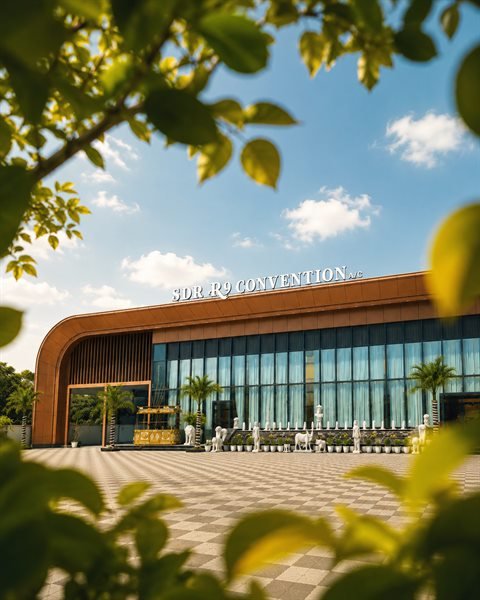 SDR R9 Convention daylight facade viewed through lush garden foliage