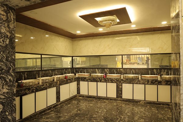Luxury vanity counter with polished granite and backlit mirrors in the restroom suite