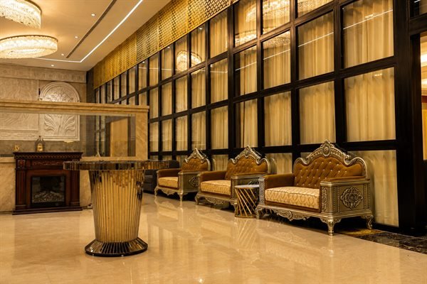 Executive pre-function reception area with decorative podium and gold lounge chairs