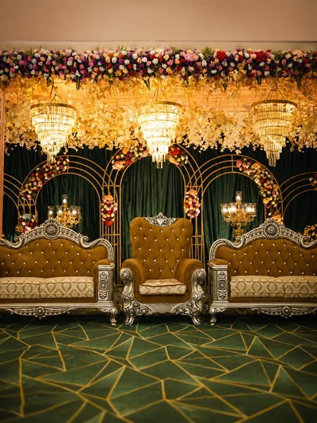 Grand royal wedding stage with floral canopy and crystal chandeliers